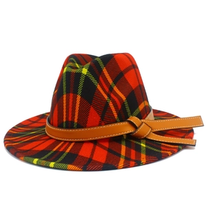 Détail d'un chapeau fedora à carreaux rouges avec motif écossais et bande en cuir chic