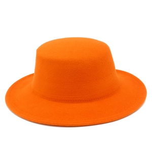 Detailed close-up of a bright orange flat top wool felt hat with smooth stitching finish