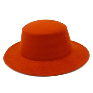 Close-up of vibrant orange wool felt boater hat featuring clean stitching and wide flat brim