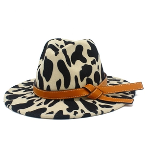 Detail of the cow print felt cowboy hat featuring a brown leather band and fine stitching