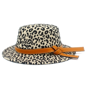 Detail of leopard print fedora hat featuring a brown leather band and decorative knot
