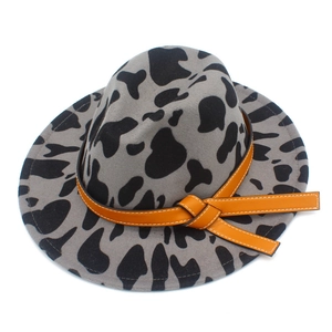 Close-up of cow print wool fedora hat with a decorative orange leather-like band