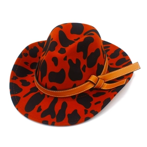 Detailed close-up of orange cow print felt cowboy hat with a brown leather decorative band