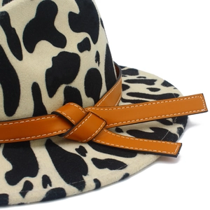 Cow print wool felt cowboy hat featuring an orange leather band with knot detail
