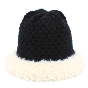Detail of black knit texture and soft white faux fur trim on winter bucket hat