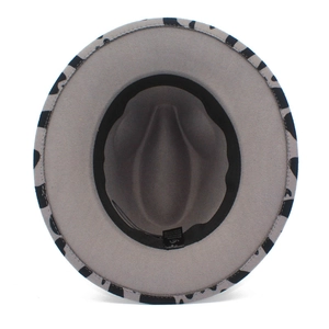 Detail view of the black and white cow print underbrim on a flat brim cowboy hat