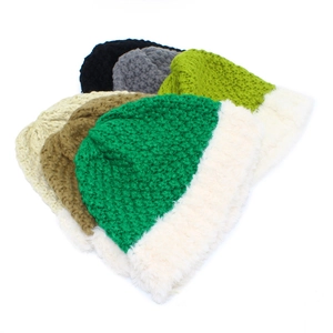 Close-up of multi-colored retro knit beanies with thick faux fur trim on white background
