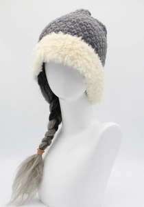 Detail of grey knitted winter hat with thick cream faux fur brim for cold weather