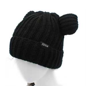 Dettaglio del cappello in maglia nera con orecchie da orso e etichetta tessuta ppsw