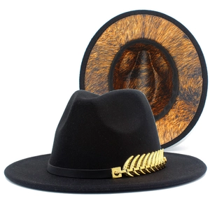 Detail of wool fedora hat featuring golden leaf ornament and leopard print brim underside