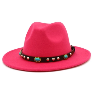 Detail eines fuchsiafarbenen Fedora-Hutes mit Türkissteinen und silbernen Nieten auf Leder
