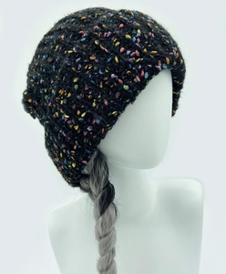 Detail of black knit beanie with colorful speckles on a model for winter warmth