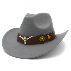 Dettaglio cappello cowboy in feltro grigio con emblema testa di toro e fascia in cuoio