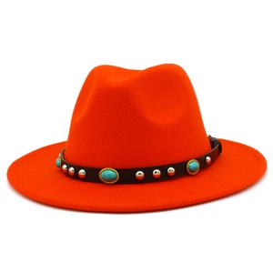 Close-up of turquoise stones and silver studs on the black belt of an orange fedora hat