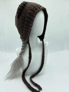 Detail van de donkerbruine gebreide muts met kattenoren en lange veters op model