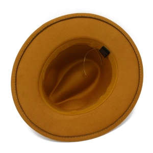 Internal detail of a mustard yellow fedora hat showing the sweatband and material label