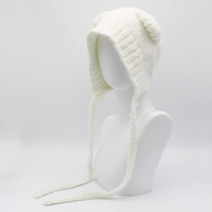 Detail van de zachte witte gebreide muts met berenoren en lange decoratieve hangende bandjes