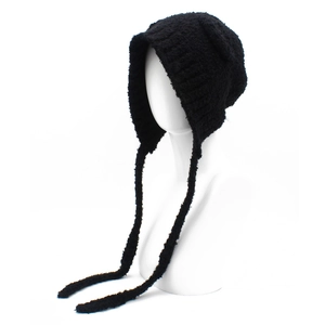Detail van de dikke zwarte teddy fleece gebreide muts met oorkleppen en lange strikbanden