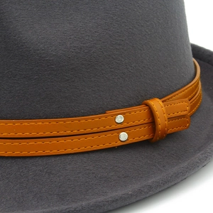 Detail of dark gray felt fedora featuring double-layer brown leather band with silver studs