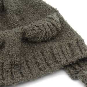 Detailopname van de dikke grijze boucle gebreide textuur van een warme wintermuts