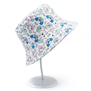 White bucket hat with cartoon dog prints and WOOF text on a white display stand