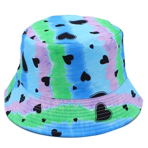 Detail view of tie-dye sun hat with vertical blue green stripes and black heart pattern