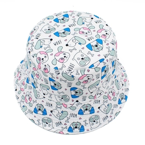Detail of white bucket hat featuring blue and pink cartoon dog patterns and Woof text