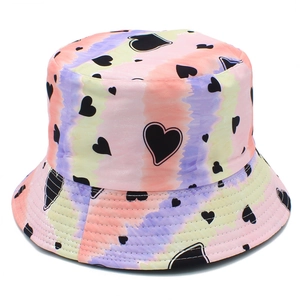 Detailed view of colorful tie-dye bucket hat with black heart pattern print