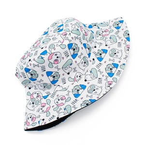 Close-up of white bucket hat with colorful cartoon dog prints and WOOF patterns