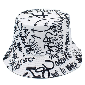 Detail of white bucket hat featuring black graffiti letters and stitched brim design
