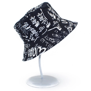 Close-up of black cotton fisherman hat with white street style graffiti print and letters