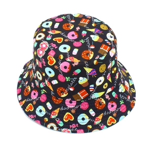 Détail de l'imprimé cupcake et sucette sur le tissu d'un chapeau bob noir