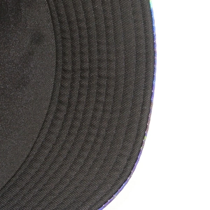 Detail shot of black bucket hat brim with concentric stitching and iridescent rainbow piping