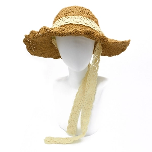 Handcrafted crochet straw sun hat for women featuring lace ribbons and a wide wavy brim