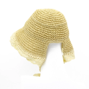 Dettaglio di cappello in paglia con bordo in pizzo bianco e trama intrecciata traspirante