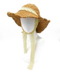 Detail of hand-woven straw sun hat featuring yellow lace ribbon and wavy brim edges