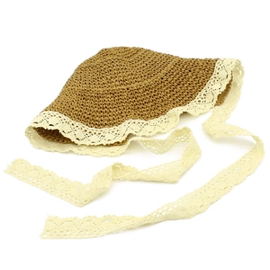 Dettaglio cappello di paglia vintage con rifiniture in pizzo beige e nastri laterali