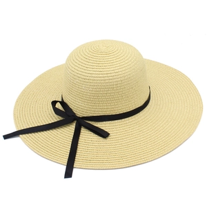 Detailed close-up of woven straw texture and elegant black bow ribbon on a sun hat