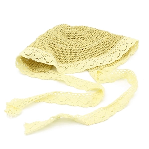Dettaglio cappello di paglia con bordo in pizzo bianco e nastri in pizzo floreale