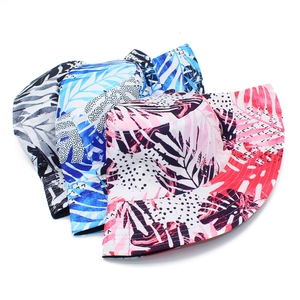 Tropical palm tree print bucket hats in pink, blue, and black for sun protection