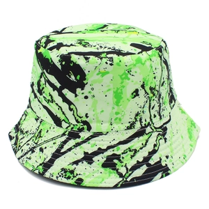 Détail du chapeau bob vert néon avec motifs graffitis de taches d'encre noire et bord rond