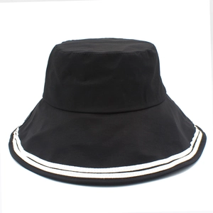 Detail of a black cotton bucket hat with white double stripe trim and wide brim