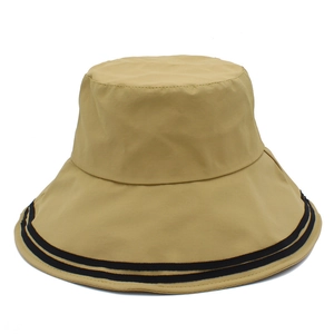 Detail of khaki wide-brim sun hat featuring black stripe accents and smooth fabric