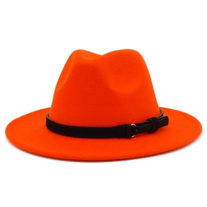 Detail of bright orange wool fedora hat with black band and gold buckle accent