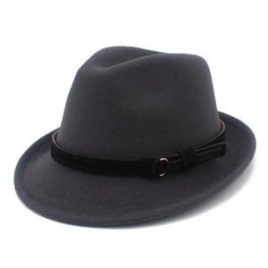 Detailed macro view of dark grey wool fedora hat with a black matte band and gold buckle