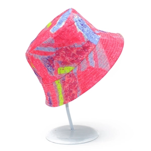 Detailed view of tie-dye bucket hat with pink, blue, and yellow patterns on a white stand