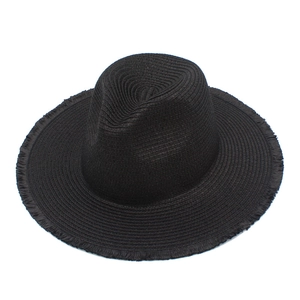 Close-up of black raffia fedora hat showing woven texture and raw fringe edge detail