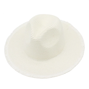 Close-up of white woven raffia sun hat showing textured brim and raw fringe detail
