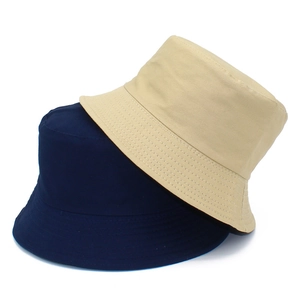 Vue détaillée des bobs en coton bleu marine et beige avec des coutures parallèles