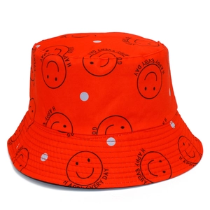 Détail du chapeau bob orange avec motif visage souriant et motifs à pois blancs